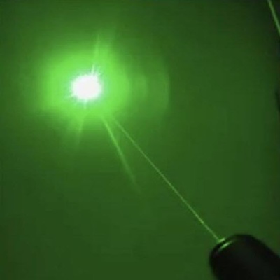 Green laser shining in sky