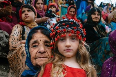 An aged/aging grandma and her young grandchild watching the “Nowruz” ceremony