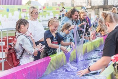 Kids playing with slime in a huge vat
