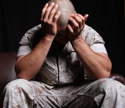 Military Marine soldier suffering PTSD covering face with hands