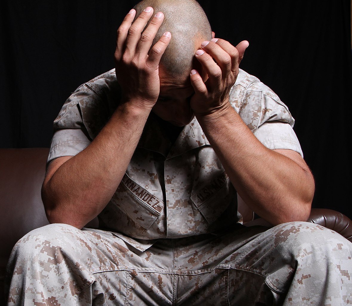 Military Marine soldier suffering PTSD covering face with hands