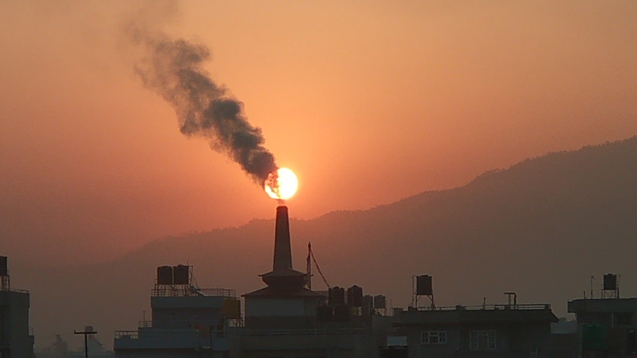 Smoggy air pollution rising from a smokestack at a brick factory