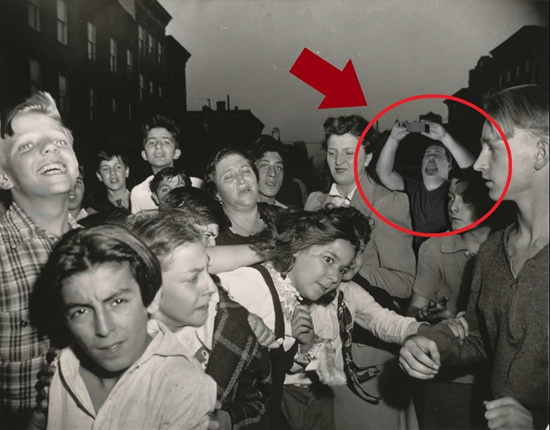 Man in old photo appears to be taking a picture with a modern-day cellphone