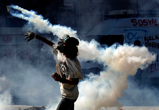 Civilian throwing a homemade tear gas bomb