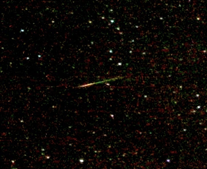 A green and red Orionid meteor