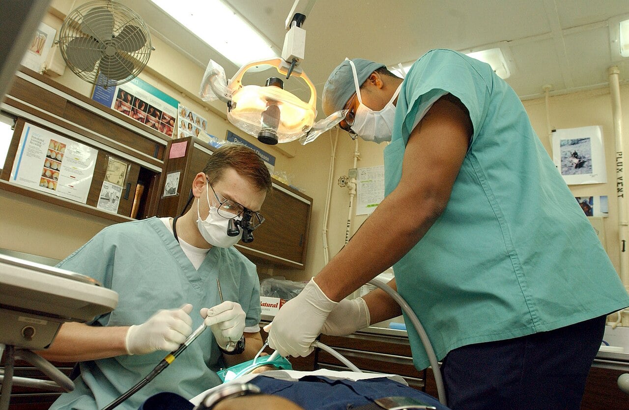 Silver diamine fluoride could end drilling for many kids’ cavities 1 At sea aboard USS Theodore Roosevelt (CVN 71) Jan. 24, 2003 -- Navy Dentist Lt. Benjamin Anderson (seated left) from Farmville, Va., and Dental Technician Lennard Henry from Ashland, Ky., perform a routine procedure on one of the ship’s crew.